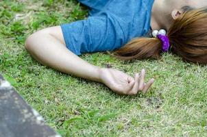 jung asiatisch Frau Ohnmacht auf Gras im Park im Sommer- weil draußen von heiß Wetter foto