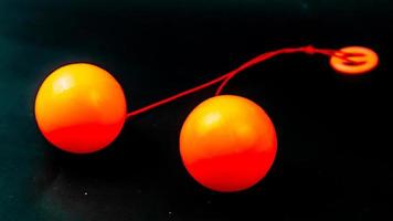 Spielzeug lato lato orange auf schwarzem Hintergrund foto