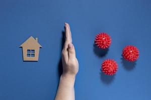 flache Hand, die Haus vor Viren schützt, Konzept auf blauem Hintergrund