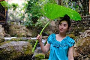 Frau mit Blatt als Regenschirm foto