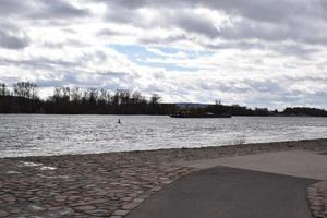 Stein direkt am Wasser beim das Rhein mit ein Schiff im das Schatten foto