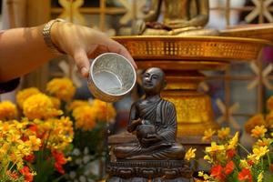 thailändisch Buddhisten verwenden thailändisch traditionell Parfüm zu Baden Buddha Bilder im Songkran Festival. im bestellen zu reinigen das Geist, es ist berücksichtigt zu verbessern das der Wohlstand von Leben. foto