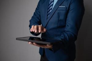 schließen oben Aussicht von jung Geschäftsmann mit Tablette zu analysieren das finanziell planen im das Büro Zimmer. foto