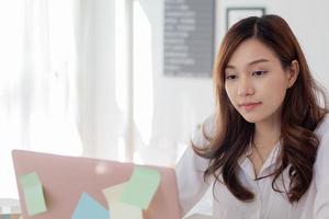 selbstbewusste und schöne Geschäftsfrau, die in einem modernen Büro arbeitet foto