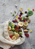 verschiedene getrocknete Früchte und Nüsse in einem Öko-Beutel foto