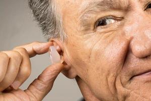 älter Mann mit Benutzerdefiniert gemacht Silikon Ohrstöpsel zum Hören Schutz foto