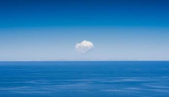 leerer klarer blauer Himmel mit einzelner Wolke in der Mitte foto