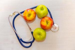 Gesundheit Konzept mit Grün und rot Äpfel und Stethoskop foto