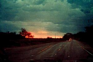 Auto Fahren Nieder ein Straße unter ein wolkig Himmel. generativ ai. foto