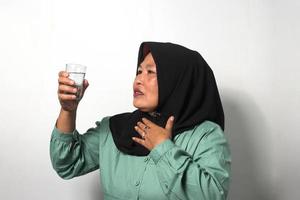 Mitte alt asiatisch Frauen tragen Hijab fühlt sich damit durstig während Ramadan Fasten foto