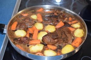 gebraten Speck mit Möhren und Kartoffeln im ein dunkel Soße foto