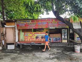 bekasi, Indonesien im November 2022. ein Kind ist Gehen im Vorderseite von ein Bus Fahrkarte Agentur. foto