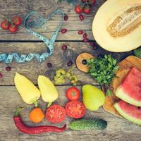 Früchte, Gemüse und im messen Band im Diät auf hölzern Hintergrund. getönt Bild. foto