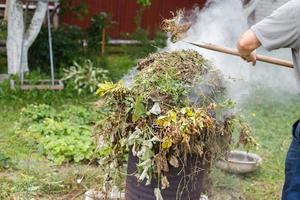 Mann Brennen Gras im das Garten foto