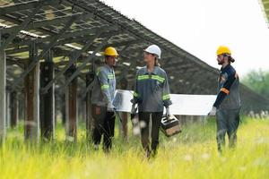 Ingenieurwesen und Techniker Entladung repariert Solar- Paneele zu Sein Eingerichtet auf das Reihen von Solar- Zellen gefüttert oben auf Hunderte von Morgen von Gras foto