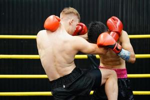 muay thailändisch, das kriegerisch Kunst von Thailand, das Leistung von ein Knie in das des Gegners Abdomen verursachen das Gegner zu haben Kolik, Dichtheit im das Bauch und verlieren durch schlagen. foto