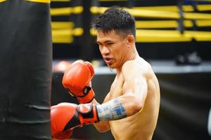 muay thailändisch, das kriegerisch Kunst von Thailand, Boxer üben Stanzen mit Stanzen Tasche zu bauen mächtig Schläge und Muskeln. foto