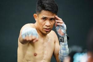 muay thailändisch, das kriegerisch Kunst von Thailand, das Boxer Probe Stanzen Vor das echt Kampf auf das Bühne es bereitet vor das Körper zum jeder Boxen passen. foto