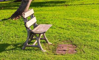 Stuhl ohne Leute, die auf einer Wiese in einem Park sitzen foto