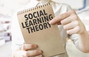 Text Sozial Lernen Theorie auf braun Papier Notizblock im Geschäftsmann Hände im Büro. Geschäft Konzept foto