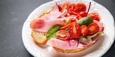 Bruschetta Tomate Sandwich Schinken, Grüner Salat Snack Mahlzeit Essen Snack auf das Tabelle Kopieren Raum Essen Hintergrund rustikal oben Aussicht foto