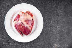 Herz roh Fleisch Innereien Schweinefleisch oder Rindfleisch Mahlzeit Essen Snack auf das Tabelle Kopieren Raum Essen Hintergrund rustikal oben Aussicht foto