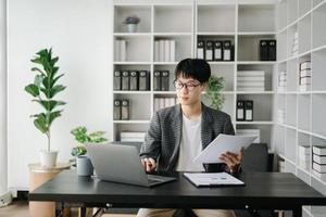 jung Geschäft Mann Exekutive Manager suchen beim Laptop Aufpassen online Webinar Ausbildung oder haben virtuell Treffen Video Konferenz tun Markt Forschung Arbeiten im Büro. foto