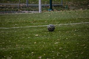 Fußball Lügen auf Grün künstlich Rasen mit Herbst Blätter foto