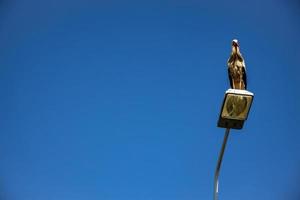 weiß schwarz Storch Sitzung auf ein Stadt Strassenlicht gegen ein Blau wolkenlos Himmel Hintergrund foto