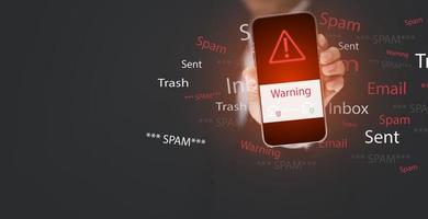 Email Konzept mit Laptop Spam und Virus Computer Monitor Internet Sicherheit Konzept, Geschäftsmann halt Smartphone mit ein Laptop. Spam, Müll und E-Marketing auf Bildschirm, Spam Email aufpoppen Warnung. foto