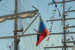 der Mast des Segelboots und die russische Flagge gegen den blauen Himmel. foto