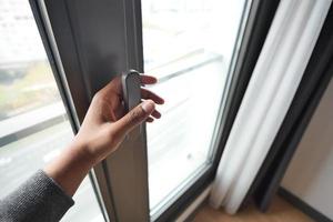 Hand öffnen schwarz Plastik pvc Fenster beim Zuhause foto