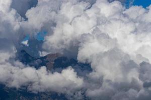 weiße, flauschige Wolken auf den Gipfeln der Berge foto