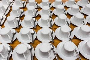 viele Reihen von rein Weiß Tasse von Kaffee und Untertasse foto