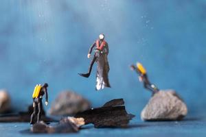 Miniaturmenschen, Taucher räumen Plastikmüllverschmutzung auf, die im Ozean weggeworfen wird, Unterwasserverschmutzungskonzept foto