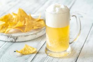 Becher von Bier mit Tortilla Chips foto