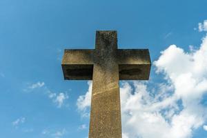 großes Kreuzsymbol aus Stein gegen einen blauen Himmel foto
