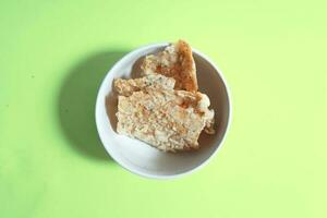 Bohnenkraut Snack, Tempeh Chips im ein Weiß Schüssel auf ein Grün Hintergrund - - indonesisch Straße Essen foto