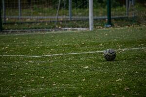 Fußball Lügen auf Grün künstlich Rasen mit Herbst Blätter foto