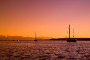 Segelboote bei Sonnenuntergang an der Westküste von Britisch-Kolumbien foto