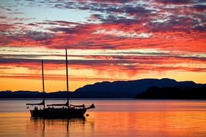 Segelboot bei Sonnenuntergang an der Westküste von Britisch-Kolumbien foto