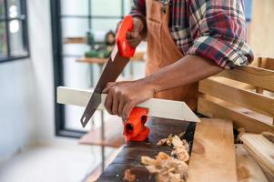 professioneller Zimmermannmann, der mit Werkzeug der Holzindustrie arbeitet, Handwerker-Personenwerkstatt mit Holz- und Ausrüstungsholzbau foto