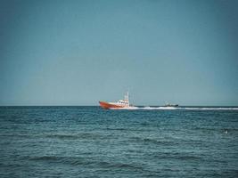 Weiß und rot Meer Rettung Schiff Segeln auf das Polieren baltisch Meer gegen das Blau Himmel auf ein warm Sommer- Tag foto