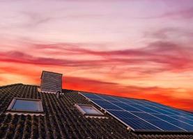 Sonnenkollektoren produzieren saubere Energie auf dem Dach eines Wohnhauses foto