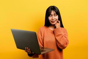 online Kommunikation Konzept asiatisch Mädchen verwenden Laptop beim Zuhause Gelb Studio Foto sie ist glücklich zu verbringen ihr kostenlos Zeit online während chatten mit freunde auf Sozial Netzwerke, Einkaufen oder Arbeiten online.