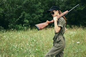 Frau auf draussen im Sonnenbrille mit ein Gewehr Jagd Reise foto