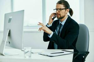 männlich Manager Sitzung beim ein Schreibtisch im Vorderseite von ein Computer Exekutive foto