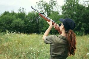 Frau auf Natur halten ein Gewehr oben Jagd Lebensstil frisch Luft foto