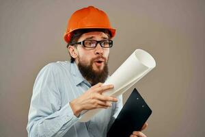 Mann im Konstruktion Uniform Orange Helm Zeichnungen Unterlagen Arbeit Dienstleistungen foto