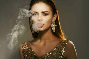 Frau golden Kleid Rauch von das Mund Dekoration Luxus foto